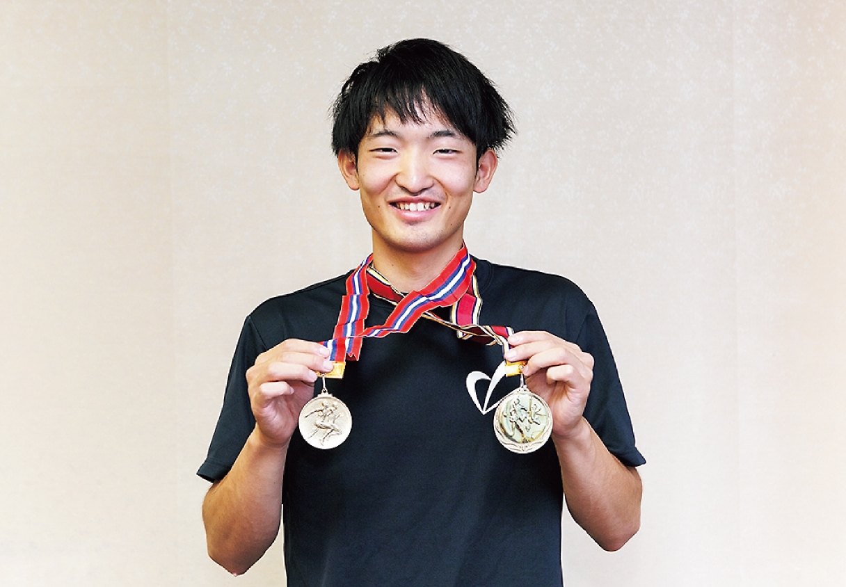 過去に獲得した金メダルを持つ柏倉選手の画像