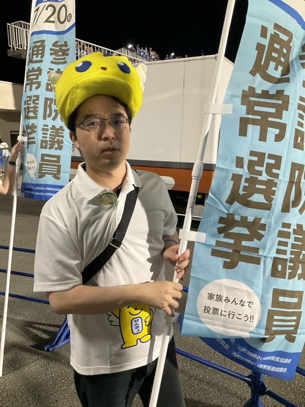 投票体験をお手伝いする中島教授の画像