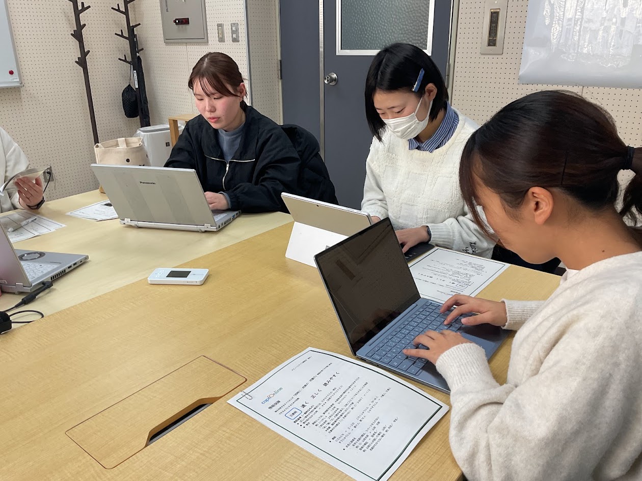 ３人の学生が椅子に座りパソコンを打っている様子の写真