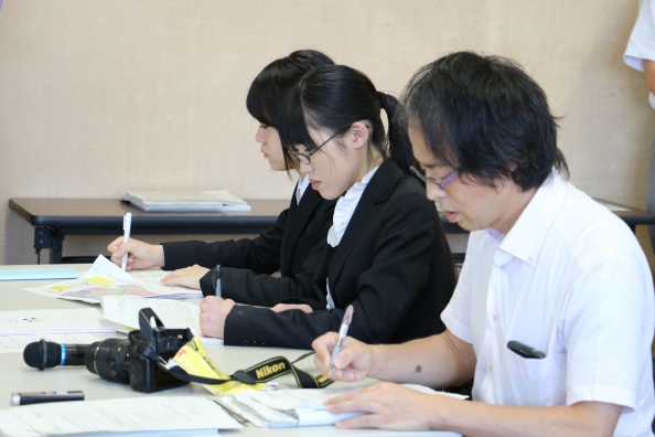 朝日新聞社の米澤記者とともに取材を行う本学学生の画像