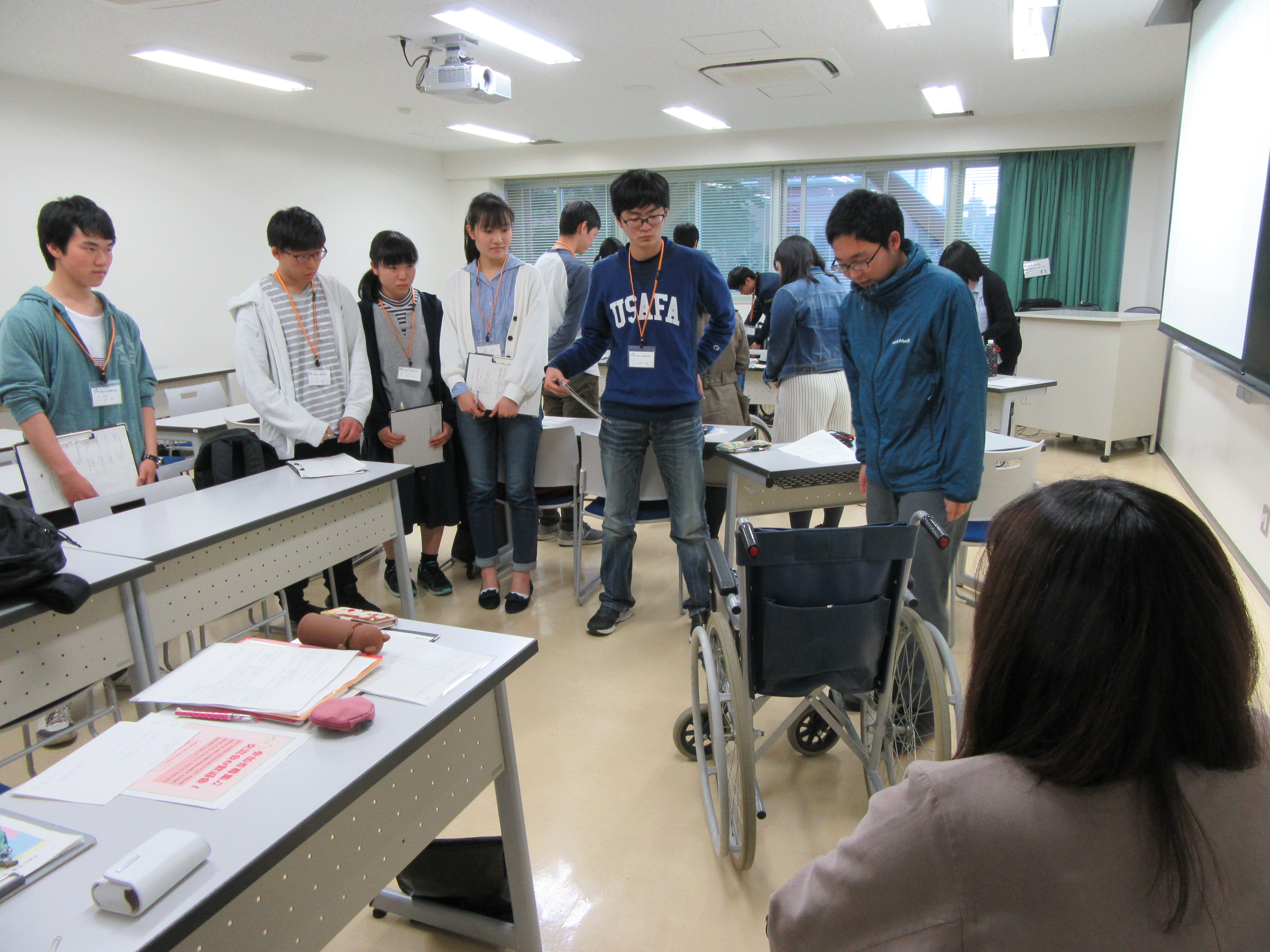 車いすの操作を説明するハトサポとそれを聞く受講生たち