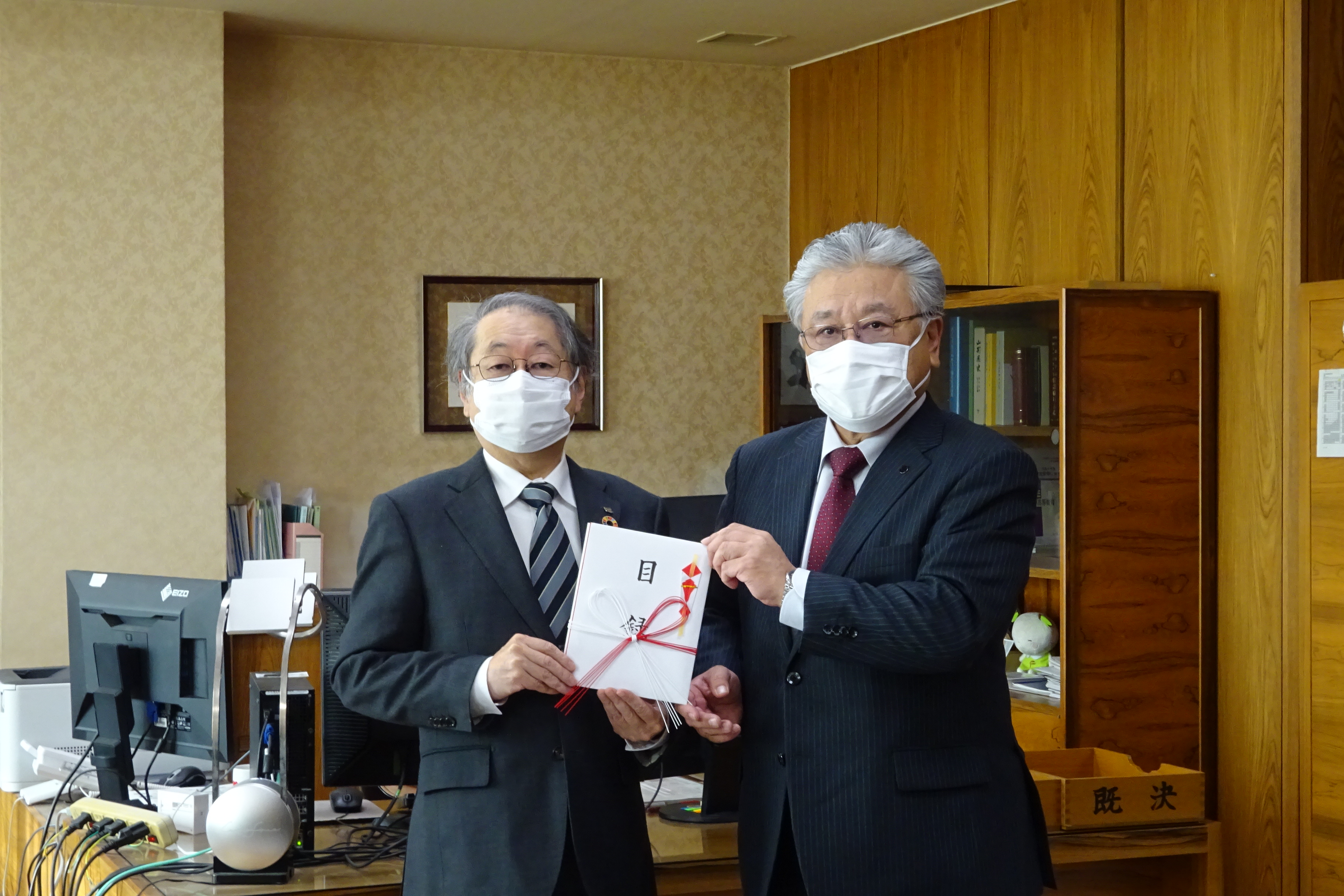 相澤社長（右）から目録を贈呈される玉手学長の画像