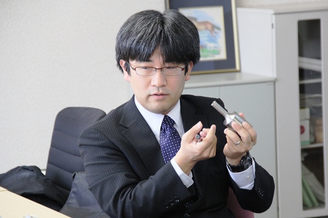「中空超音波ホーン」を手に説明する幕田准教授の画像