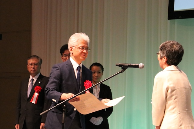 原山優子産学官連携功労者選考委員会主査から賞状を受け取る小野教授の画像