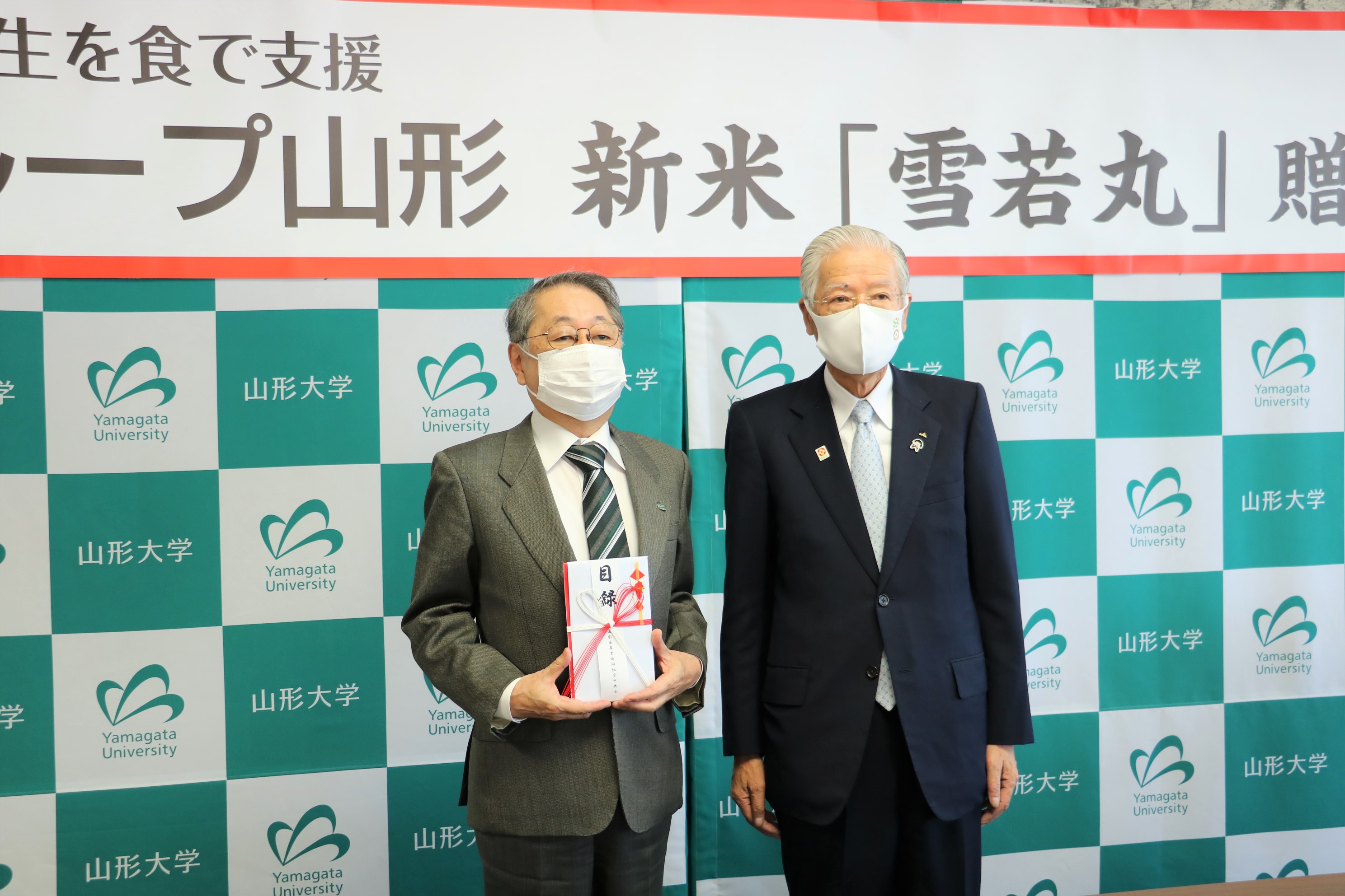 目録を手にする玉手学長と長澤代表理事会長の画像
