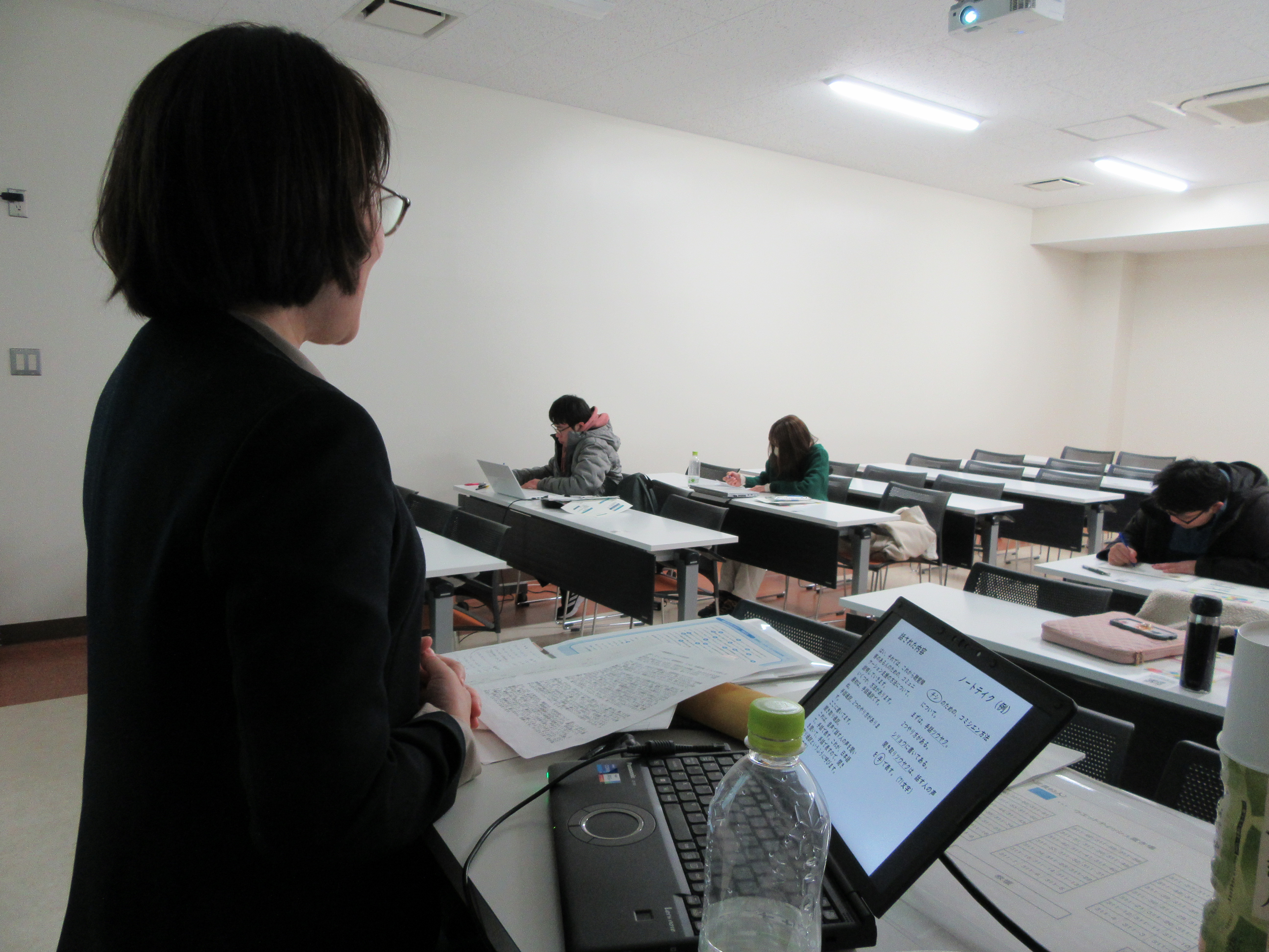 講師の前にパソコンが３台ほど並んでいる様子