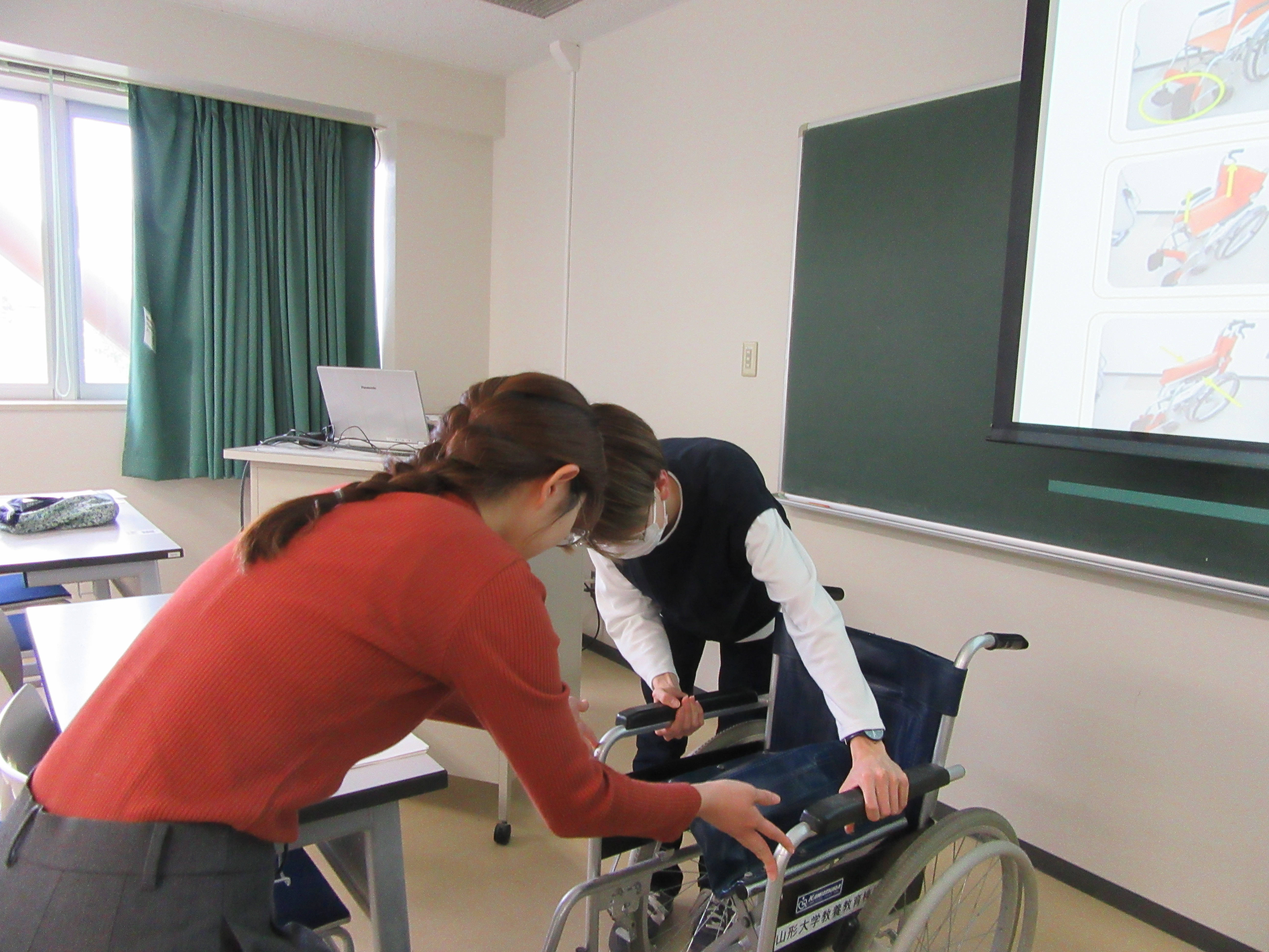 2人で車いすの使い方を確認している