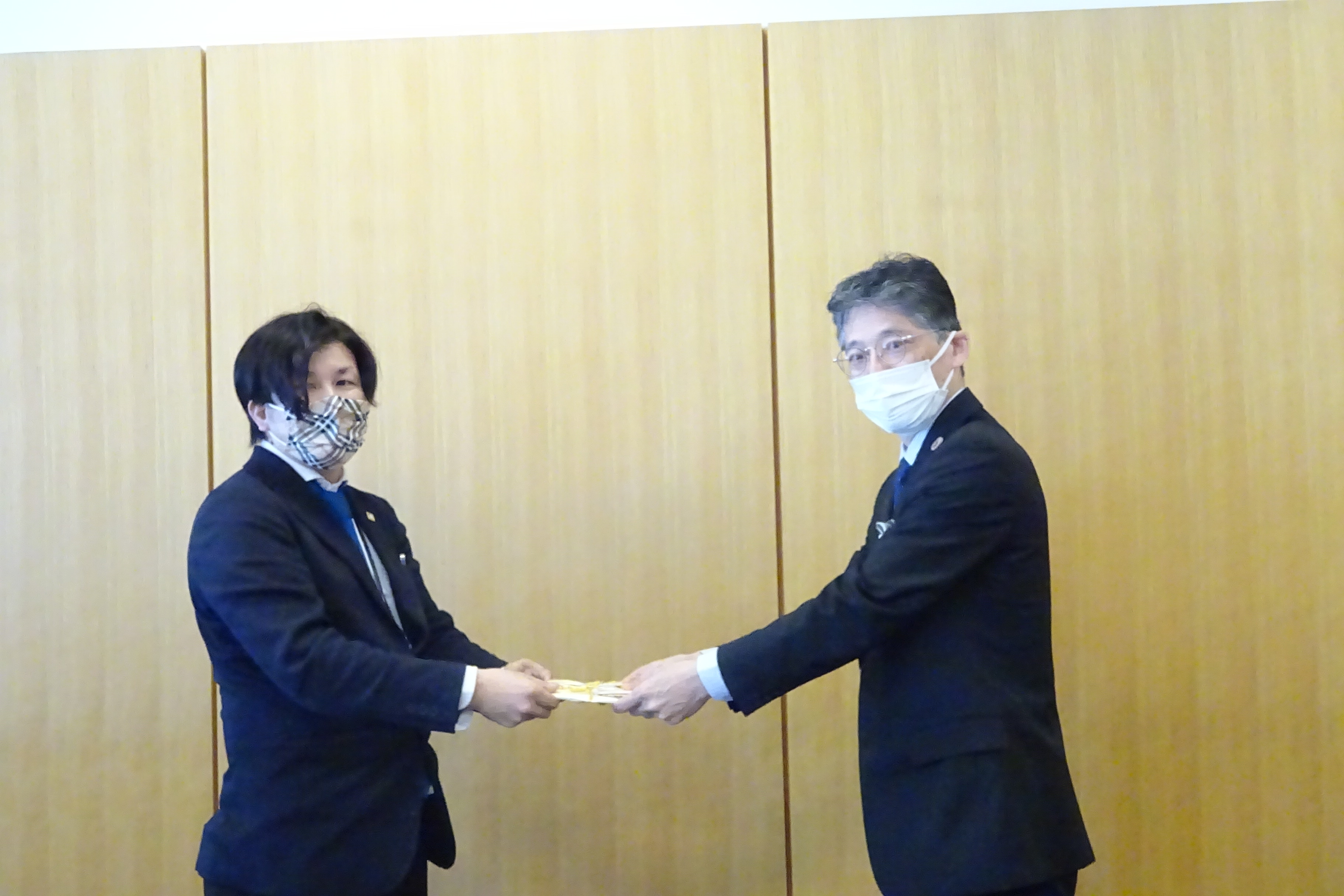 村上代表取締役（左）から目録を贈呈される黒田工学部長の画像