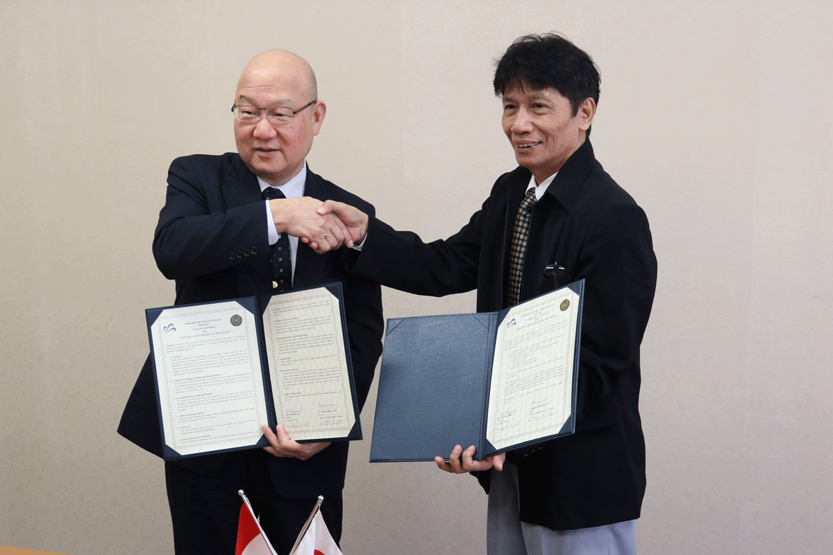 協定書を手に握手するGunawan学長(右)と安田理事
の画像