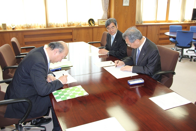協定書にサインする菅野教育長と小山学長の画像