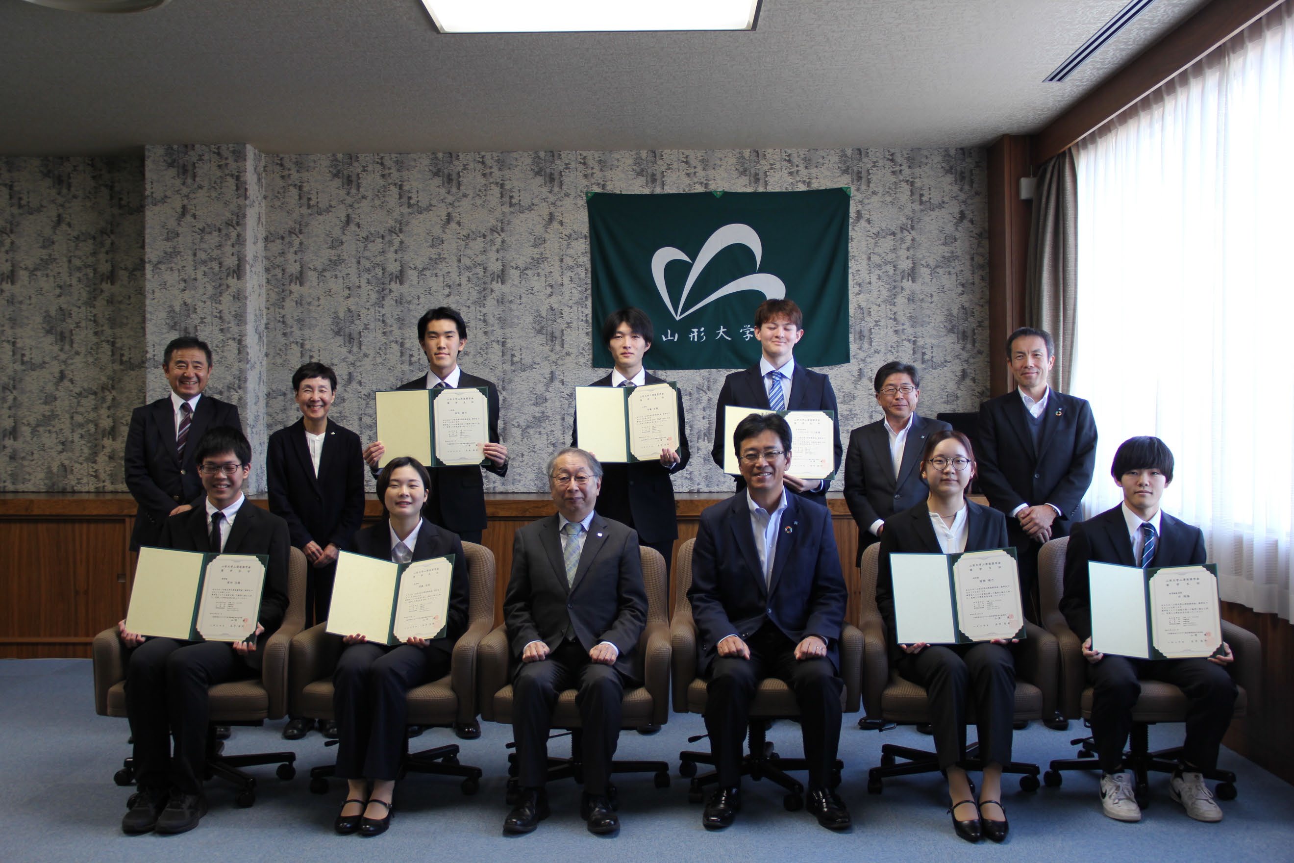 集合写真（前列中央右：山澤代表理事、中央左：玉手学長、奨学生のみなさん）の画像