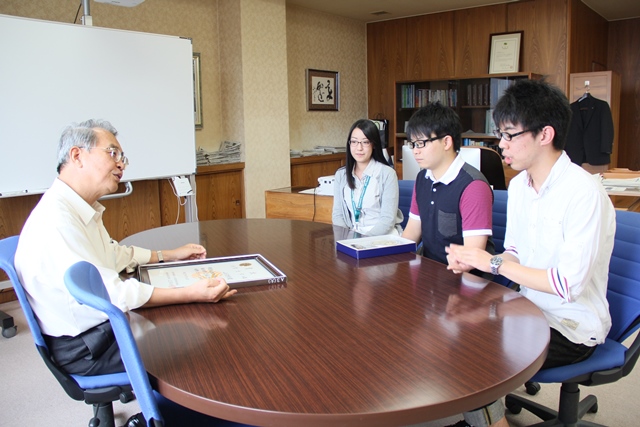 小山学長へ報告する高橋団長（右）と三浦さん（中）の画像