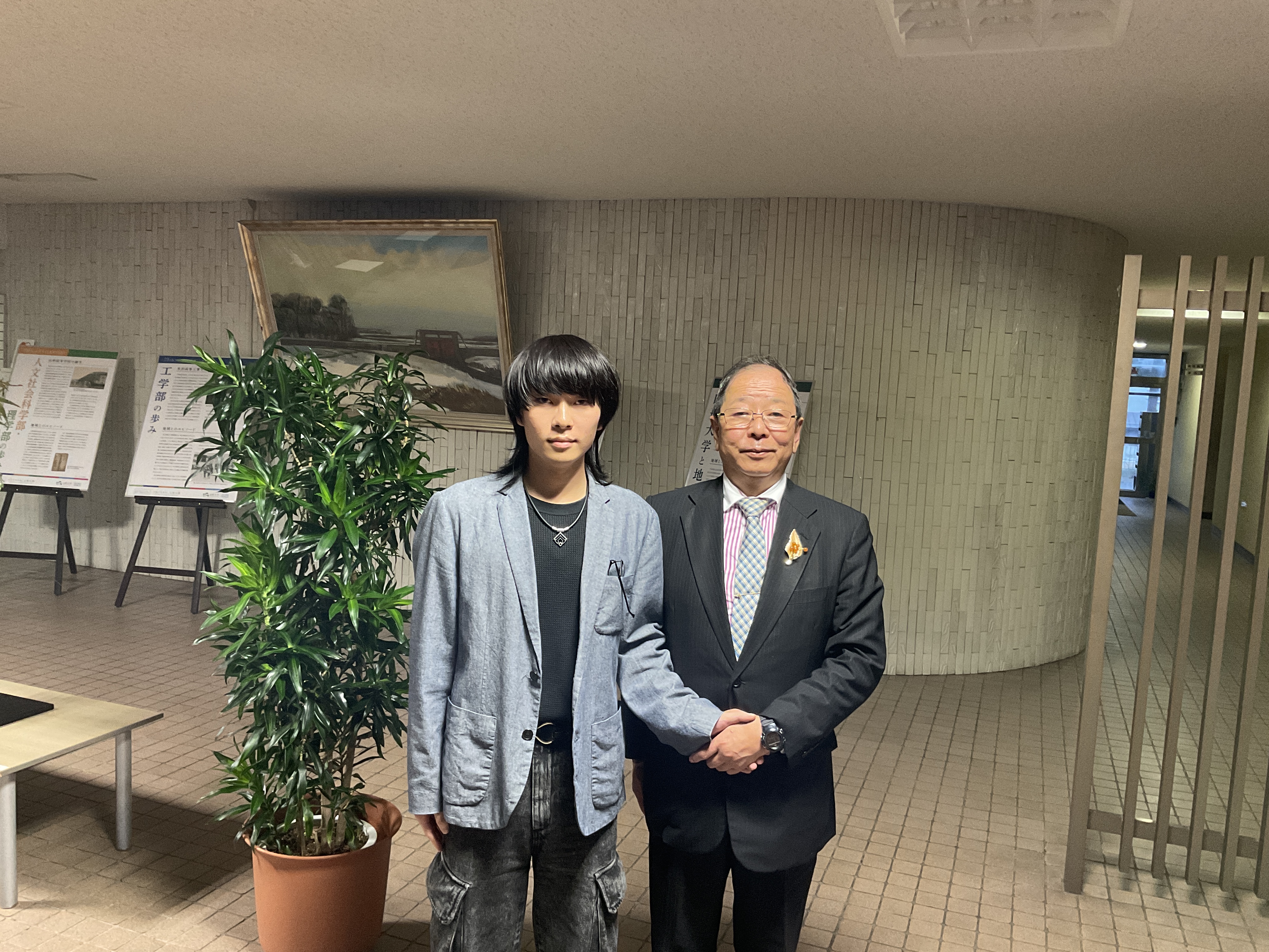 佐々木様（右）から激励される赤石さん（左）の画像