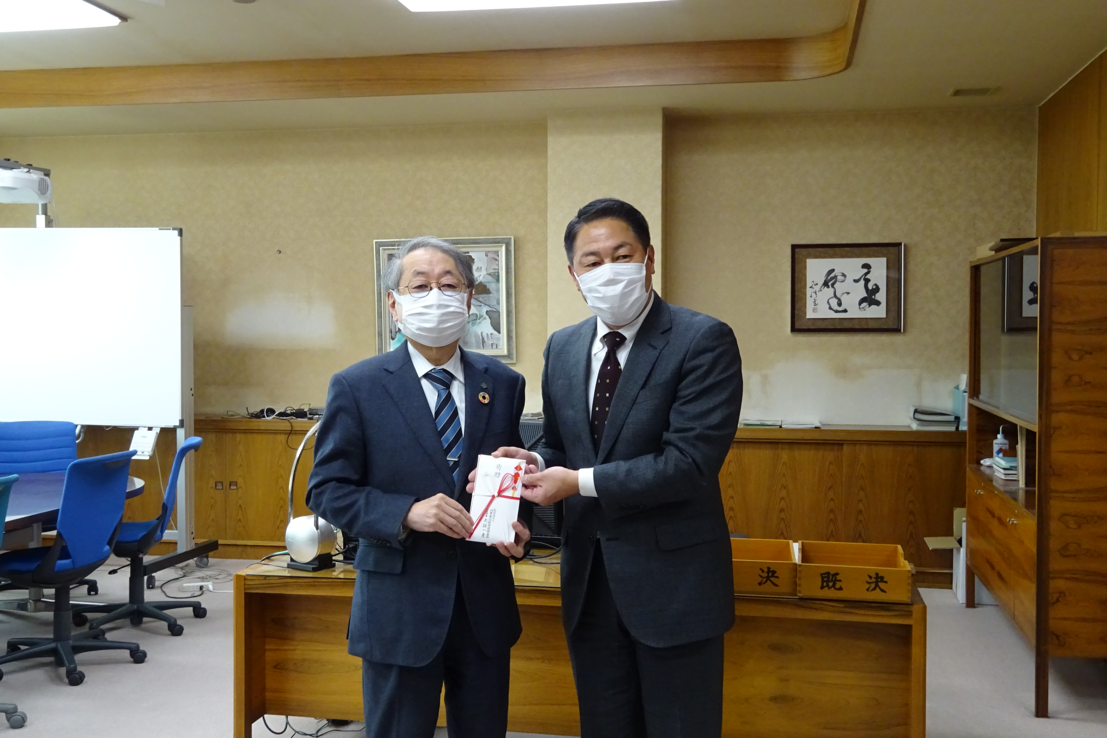 遠藤取締役（右）から寄付金を贈呈される玉手学長の画像