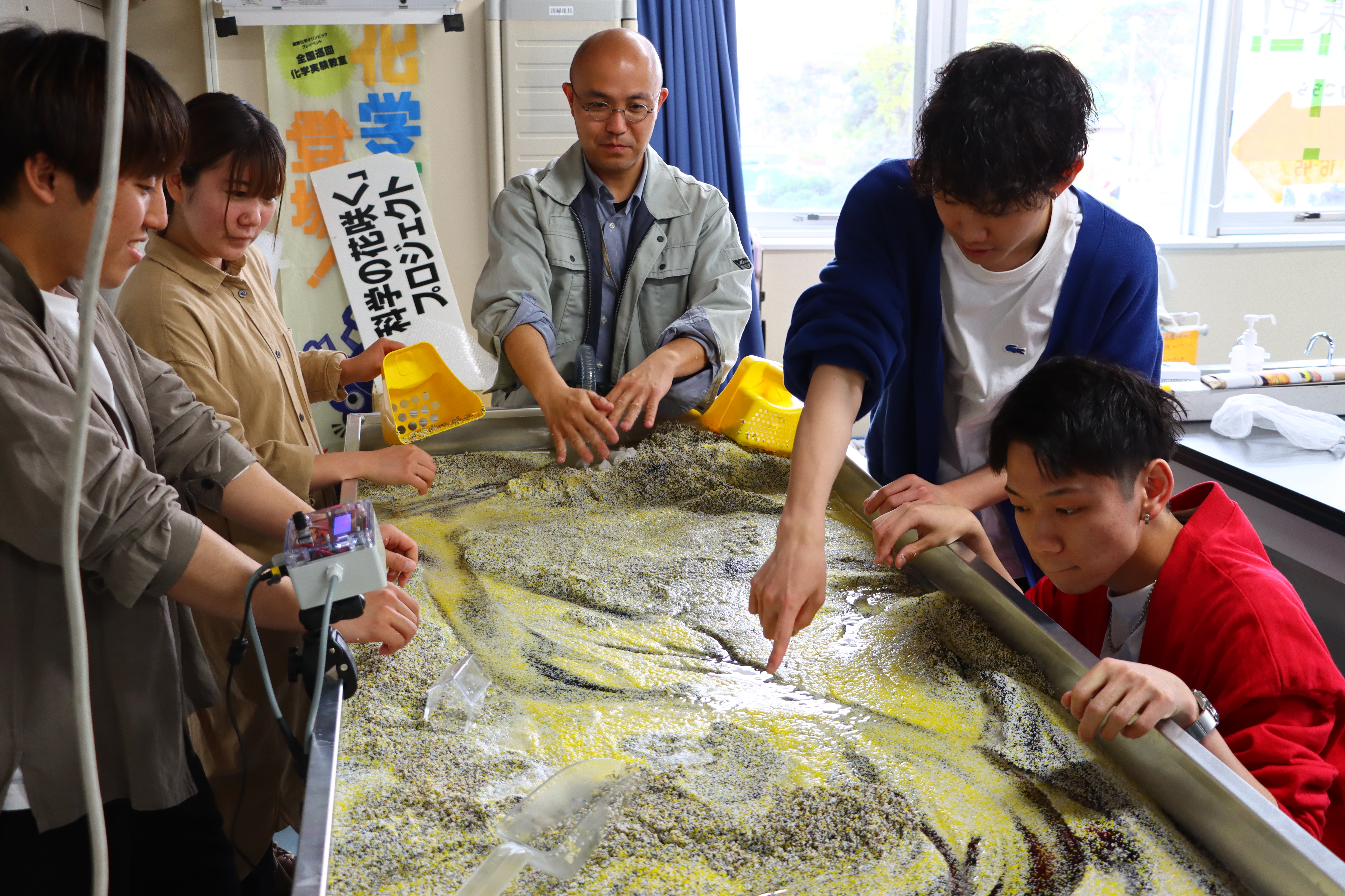 ゼミ学生が川の流れを観察する様子の画像