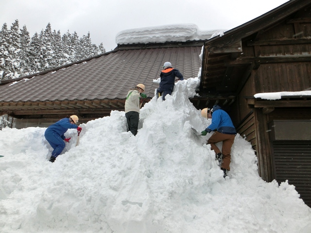 屋根から落ちた雪を崩すの画像