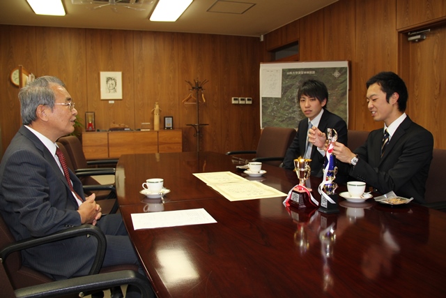 学長に報告する荻原さん（中）と星さん（右）の画像